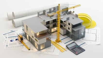 Model bloku mieszkalnego stojący na planach budowy