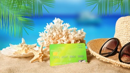 Karta kredytowa, słomkowy kapelusz, okulary przeciwsłoneczne na plaży