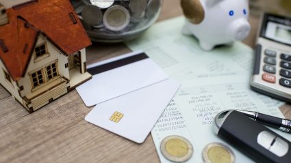 Kalkulator, piniędze i dom symbolizujące kredyt hipoteczny