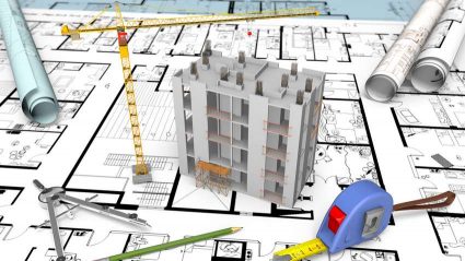 Model bloku mieszkalnego stojący na planie budowy