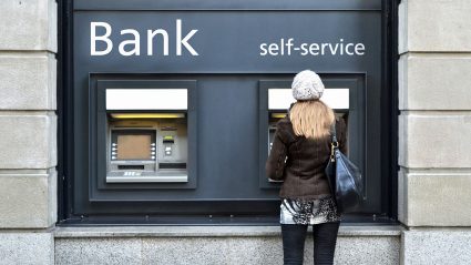 Kobieta przed okienkiem samoobsługowym banku