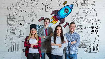 Startupy: młodzi ludzie n atle grafiki z rakietą