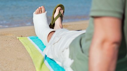 Mężczyzna ze złamaną nogą na plaży