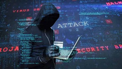 Haker z laptopem i kartą kredytową w ręku na tle napisów: cyberatak
