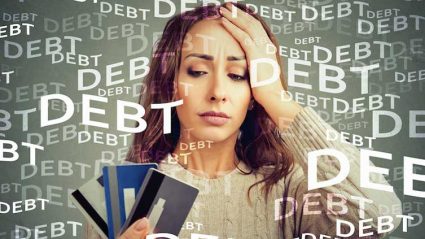 Napis dług na tle smutnej kobiety z kartami kredytowymi