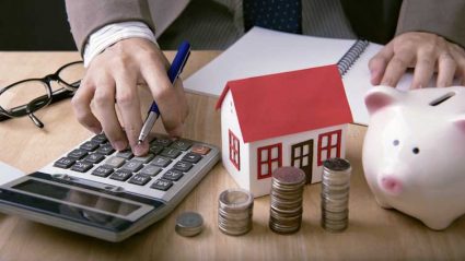 Kredyt hipoteczny - model domu, pieniądze i skarbonka