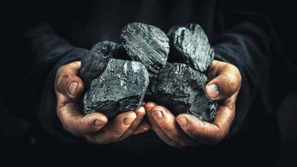 Górnik trzymający węgiel
