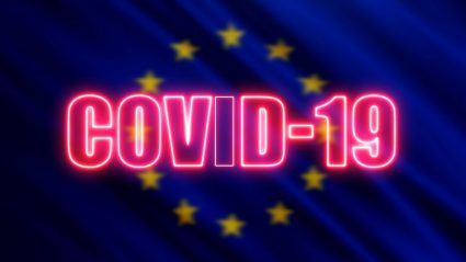 Napis COVID-19 na tle flagi Unii Europejskiej