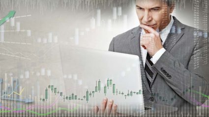 Inwestor patrzący na wykresy na komputerze