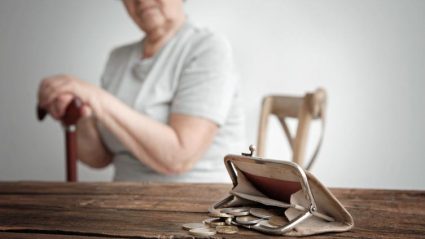Starsza kobieta patrząca na pusty portfel