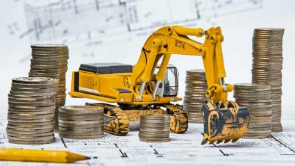 Pieniądze i maszyny budowlane na planach inwestycyjnych