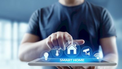 człowiek trzymający tablet, napis smart home, ikony
