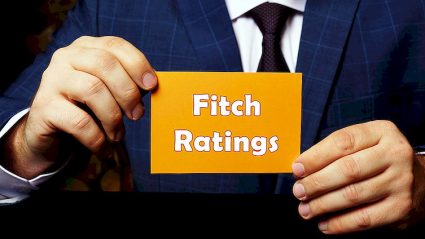 mężczyzna trzymający kartkę z napisem Fitch Ratings