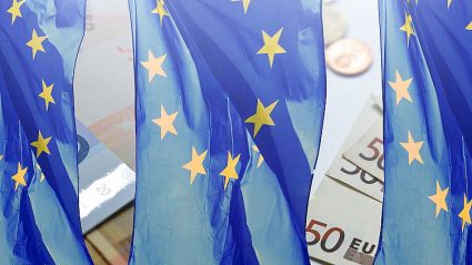 flagi UE na tle banknotów euro