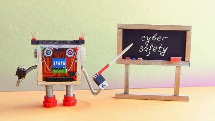 cyberbezpieczeństwo, szkoła, tablica z napisem cyber safety, robot-zabawka