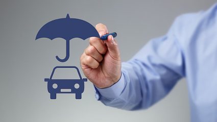 człwiek rysujący parasol nad rysunkiem samochodu