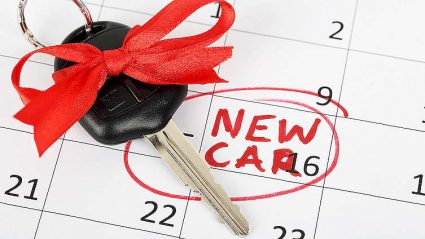 napis New car, kluczyk samochodowy ze wstązką na kartce z kalendarza