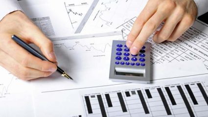 Mężczyzna dokonujący obliczeń na kalkulatorze i dane finansowe