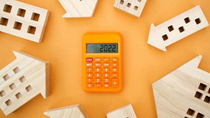 kalkulator z wyświetlonym napisem 2022, makiety domów