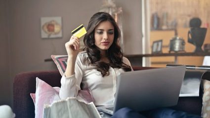 kobieta robiąca zakupy online, z kartą kredytową w dłoni, laptop