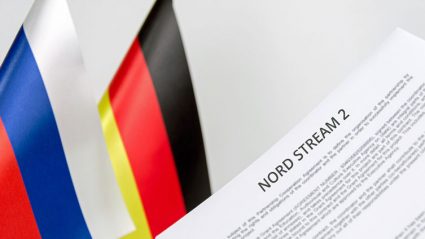 Dokumenty z napisem Nord Stream 2 na tle flag Rosji i Niemiec