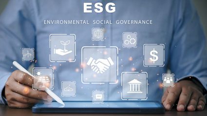 człowiek przy tablecie, napis ESG, ikony ESG