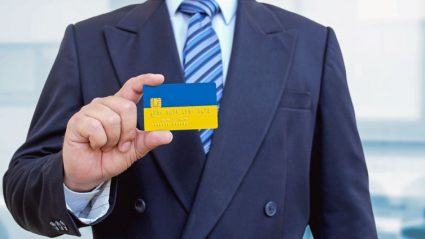 Mężczyzna trzymający kartę bankową z flagą Ukrainy