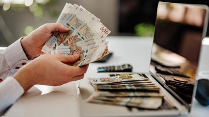 Osoba licząca pieniądze przy biurku w pracy