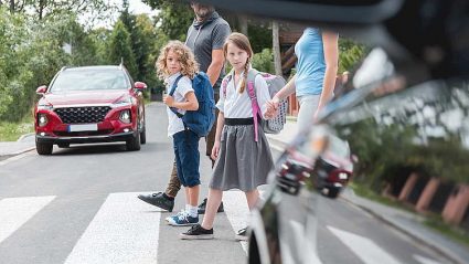 uczniowie na przejściu dla pieszych, samochody
