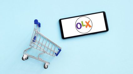 Logo OLX na telefonie komórkowym i koszyk zakupowy