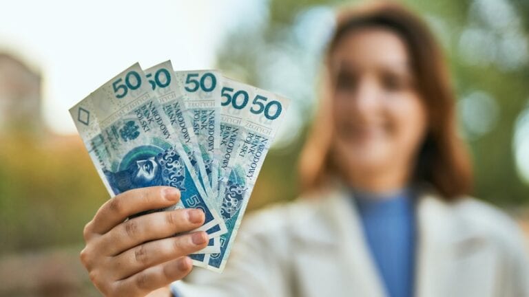 młoda kobieta z banknotami 50 zł w dłoni